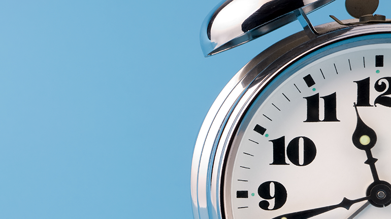 Analog alarm clock depicting 11:42.